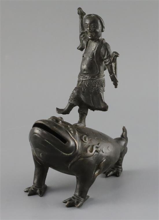 A late Ming bronze joss stick holder of Lui Hai standing on the back of a three legged toad, width 9cm depth 17cm height 22cm